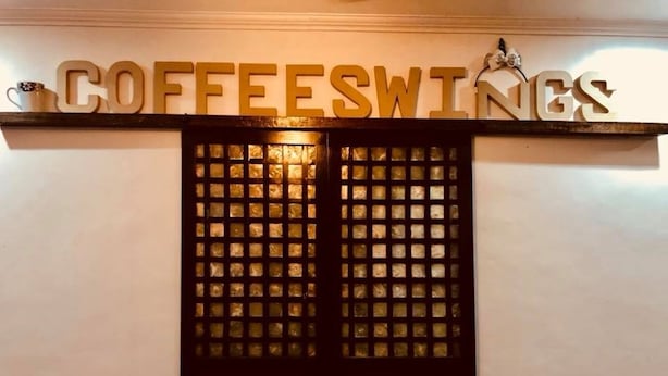 A wall with the words "COFFEE SWINE" in large letters above a decorative panel. - Coffee Swings Lodging House (Vigan)