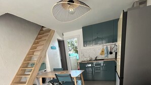Ein zeitgemäßer Wohnraum mit Treppe, Essbereich, Küche und einer Couch.