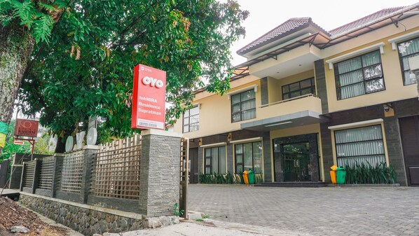 A modern residential building with a stone facade, large windows, and a gated entrance. - OYO 1740 Tekmira Residence Supratman Syariah (Bandung)