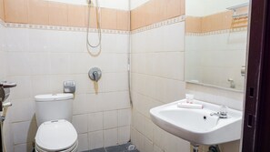 A small bathroom with a toilet, a sink, and a shower. - OYO 1740 Tekmira Residence Supratman Syariah (Bandung)