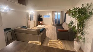 Un salón acogedor con un sofá, una mesa de comedor y una planta en maceta.