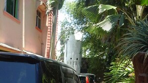 A narrow street with parked vehicles and lush greenery. - Sadiana Apartments (Mtwapa)