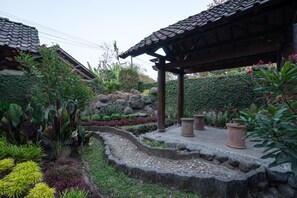 Ein traditioneller japanischer Garten mit einem Kiesweg, einer hölzernen Laube und verschiedenen Pflanzen.