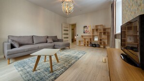 Deluxe-Apartment | Wohnbereich | 100-cm-Flachbildfernseher mit Digitalempfang, Fernseher