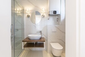 Deluxe tweepersoonskamer, balkon | Badkamer | Een douche, handdoeken, zeep, toiletpapier