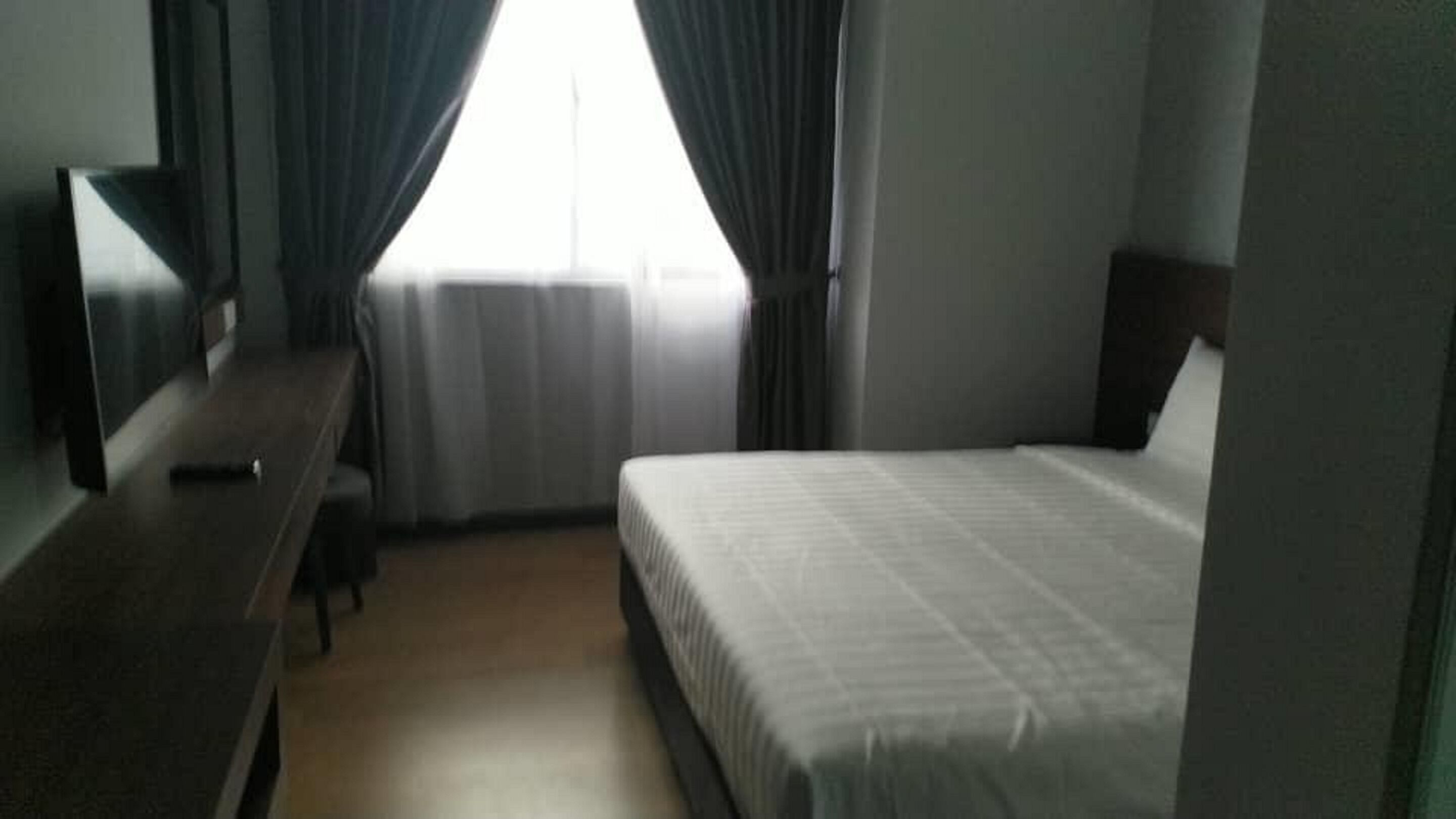 Una habitación de hotel con cama, escritorio y televisión.