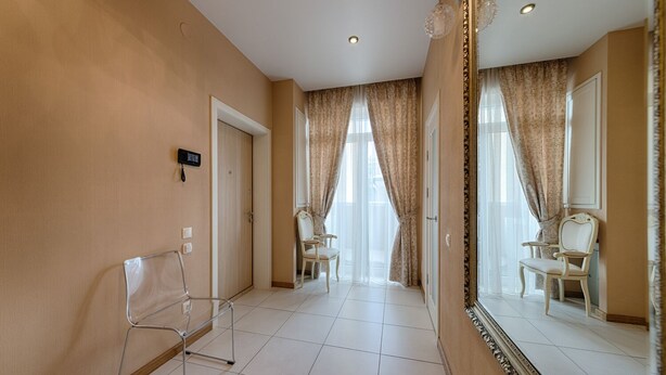 A hotel hallway with a mirror, two chairs, a phone, and a door. - HOME APART Storozhovskaya str. 6 (Minsk)