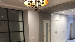 A modern living room with a beige sofa, a black coffee table, and a chandelier. - HOME APART Storozhovskaya str. 6 (Minsk)