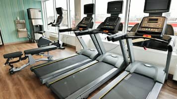 A gym with treadmills, stationary bikes, and a rowing machine.