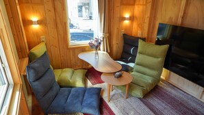 A cozy room with a sofa, a small table, and a TV. - JR Mobile Inn Sapporo Kotoni (Sapporo)