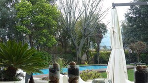 A view of a swimming pool surrounded by trees and outdoor furniture. - Le Stanze dellArte (Palermo)