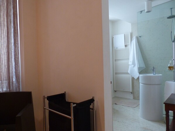 Une salle de bain équipée d’un lavabo, d’un miroir, d’un porte-serviettes et d’un radiateur.