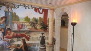 Un mural que muestra un área de piscina con gente relajándose, una fuente y una lámpara.