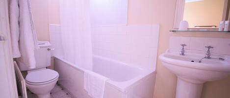 A bathroom with a toilet, bathtub, and sink.