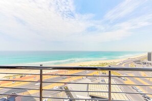 A view from a high-rise window overlooking a coastal road with a beach and ocean in the distance. - Horizon Bay 802 (Cape Town)