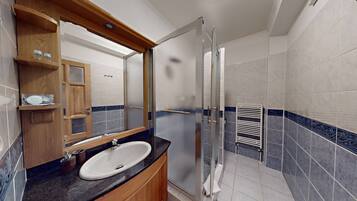 Un bagno moderno con lavandino, specchio e doccia.