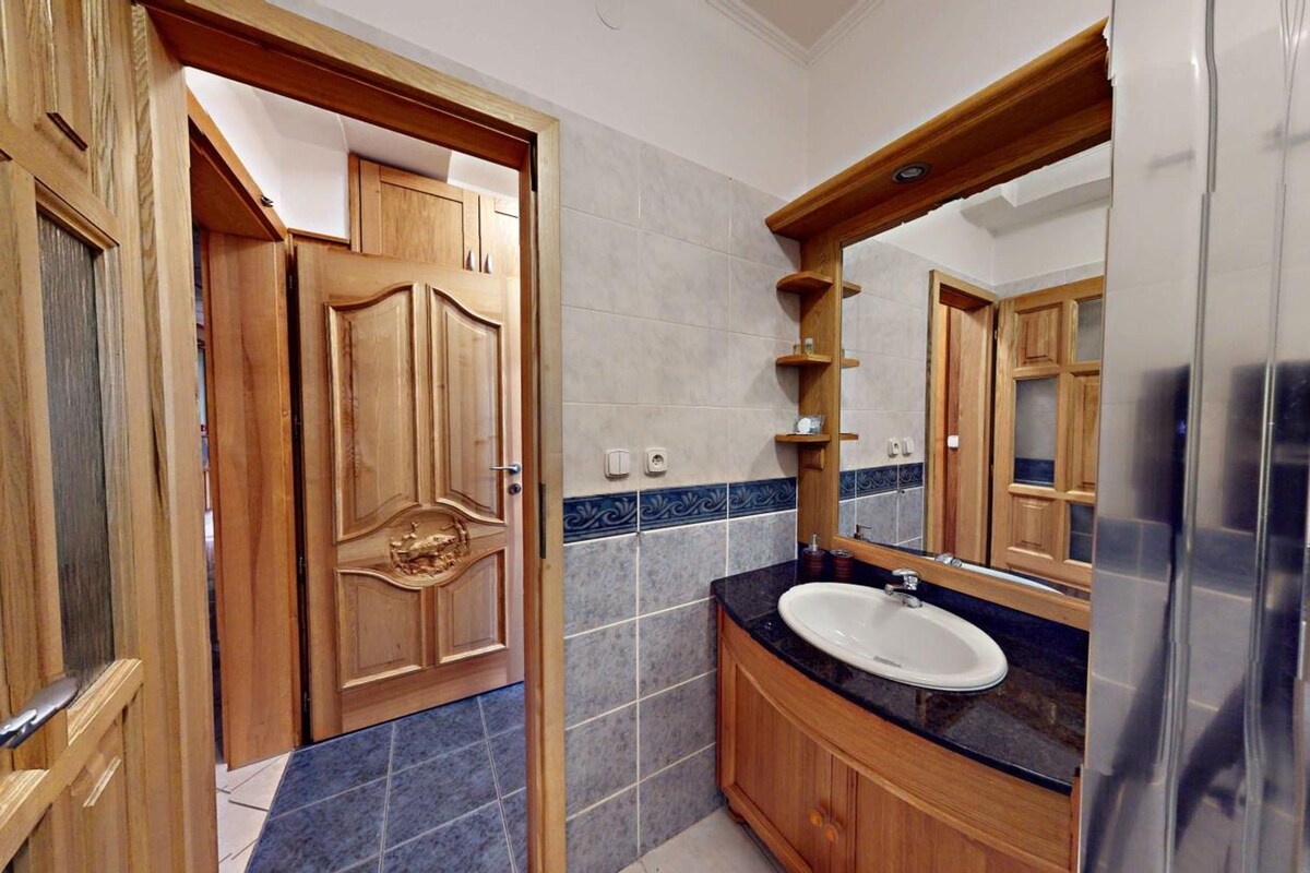 A bathroom with a wooden vanity, a sink, and a mirror.