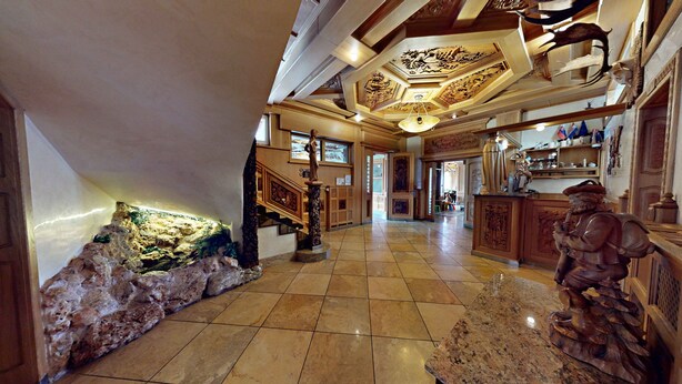 Eine geräumige Lobby mit einer Steinwand, einer Treppe und einer Statue.