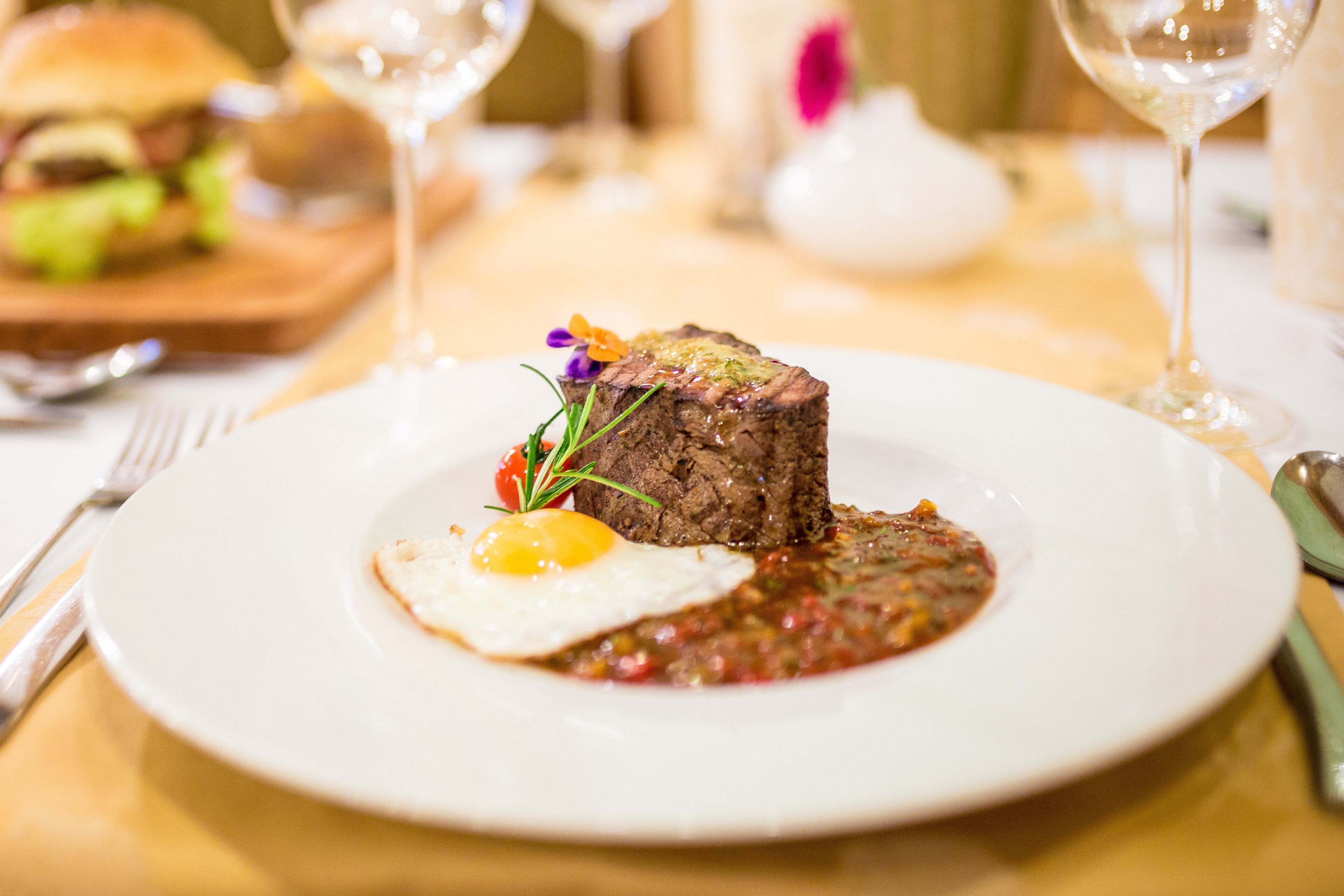 A plate with steak and a fried egg on a white plate.