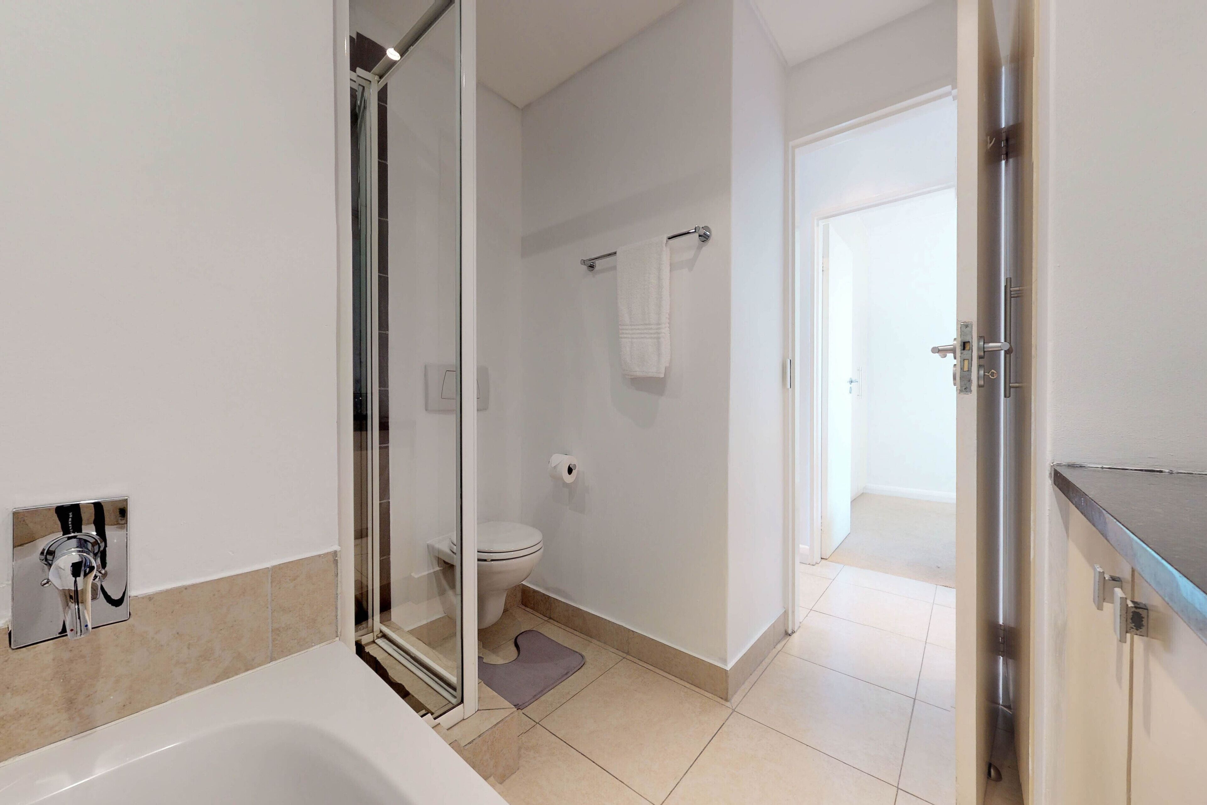 Ein modernes Badezimmer mit Duschkabine aus Glas, Toilette und Badewanne.