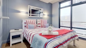 Una camera da letto con un letto, un comodino, uno specchio e una finestra.