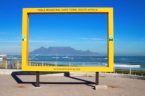 A yellow sign with the text "Table Mountain, Cape Town, South Africa" and coordinates. - Eden On The Bay Apartment 67A (Cape Town)