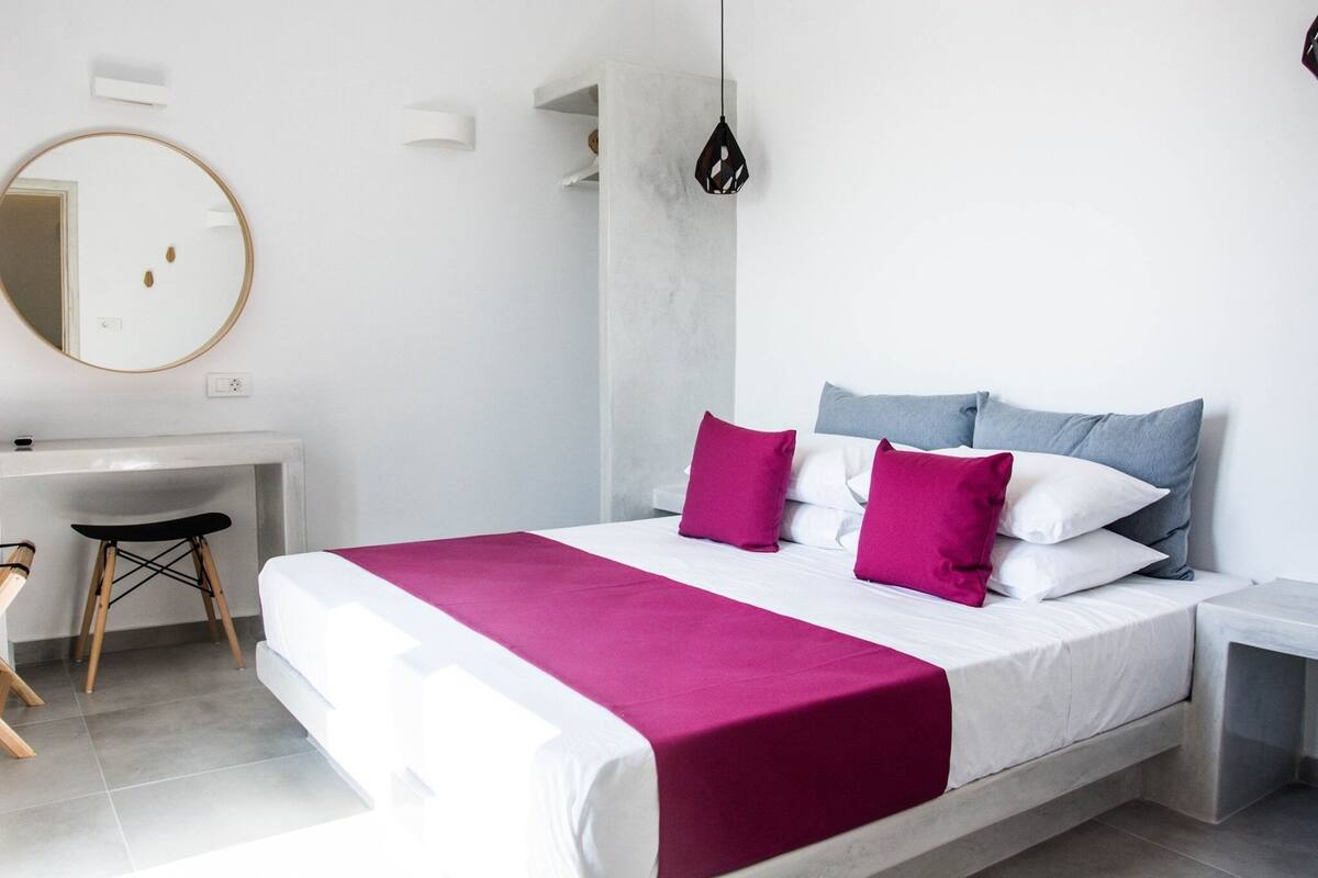 A modern bedroom with a bed, a desk, and a chair.