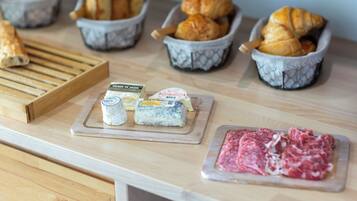 Un comptoir en bois où sont exposés divers produits alimentaires, notamment du pain, du fromage et de la viande.