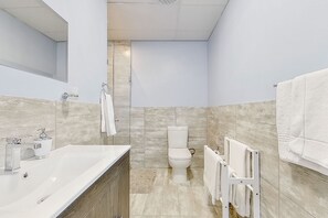 A modern bathroom with a large sink, toilet, and shower. - Eden on the Bay Apartment 67B (Cape Town)