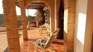 A patio area with brick columns, a covered seating area, and a view of the landscape. - Cortijo Bellavista - RV112 Cómpeta by Ruralidays (Málaga)