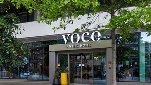 The exterior of the Voco An IHG Hotel with large glass doors, potted plants, and a modern facade. - voco Manchester City Centre by IHG (Manchester)