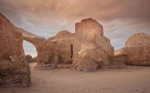 Un'antica rovina con imponenti strutture in pietra e un arco.