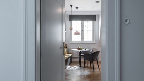 A hallway leading to a dining area with a table and chairs, a window with a view, and a door. - Hidden gem in heart of Prague (Prague)