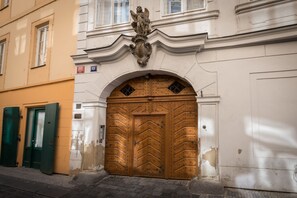A building with a large wooden door, a green door to the left, and a plaque above the door. - Hidden gem in heart of Prague (Prague)