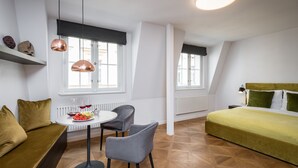 A modern room with a bed, a sofa, a dining table with chairs, and pendant lights. - Hidden gem in heart of Prague (Prague)
