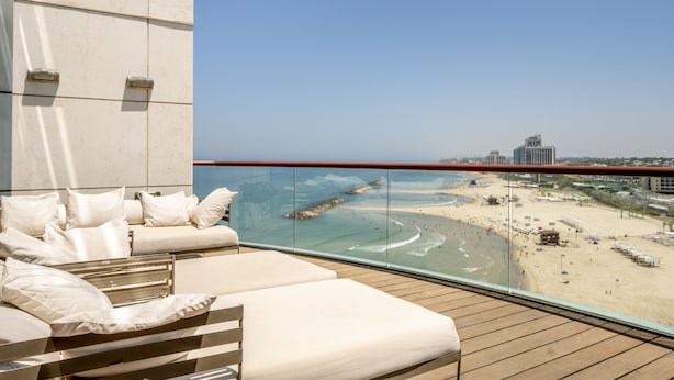 Een balkon met uitzicht op een strand en de oceaan.