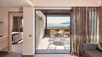 Una habitación de hotel moderna con balcón, zona de comedor y sofá.