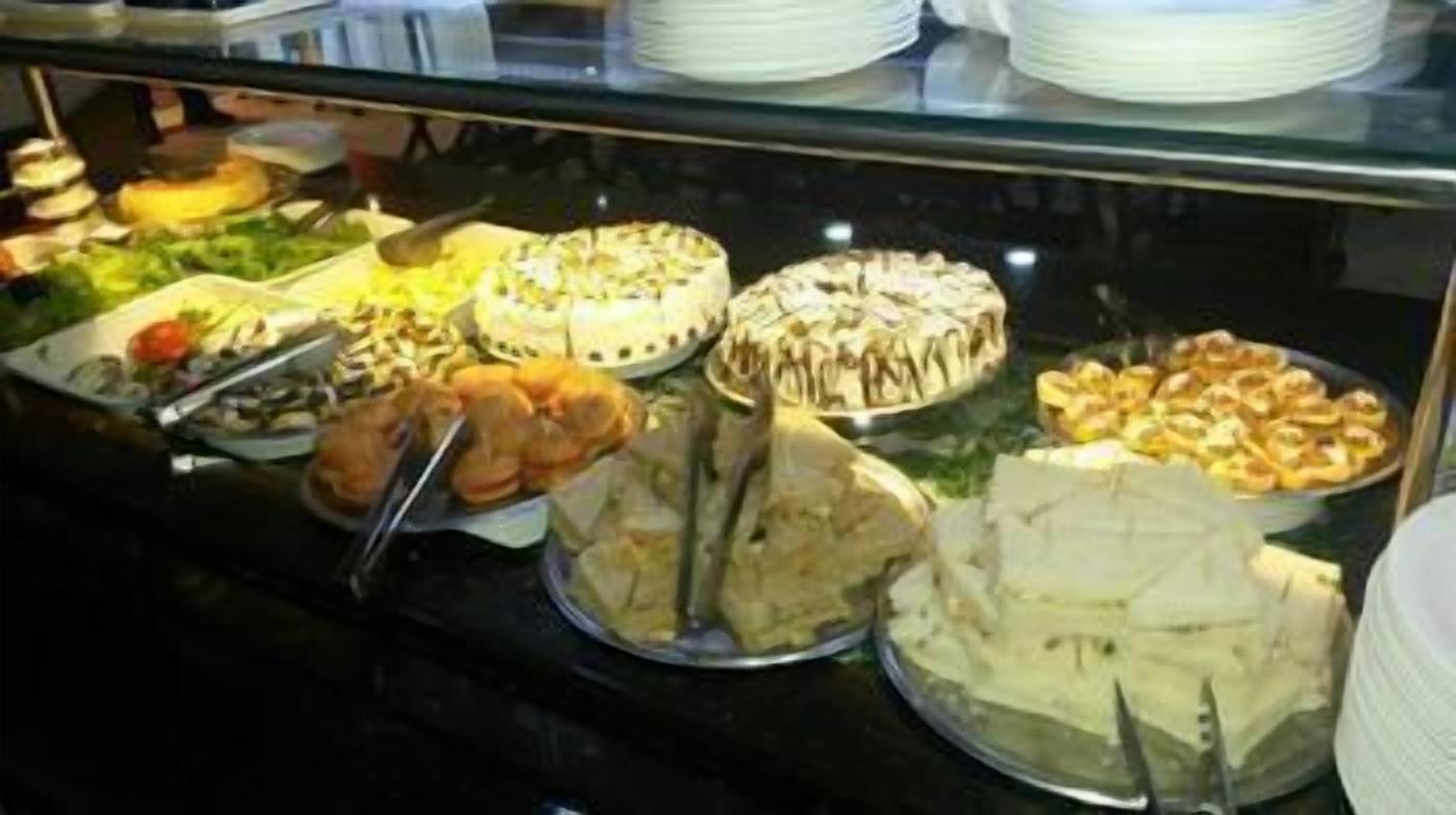 Un buffet con diversi piatti, tra cui torte, pasticcini e insalate.