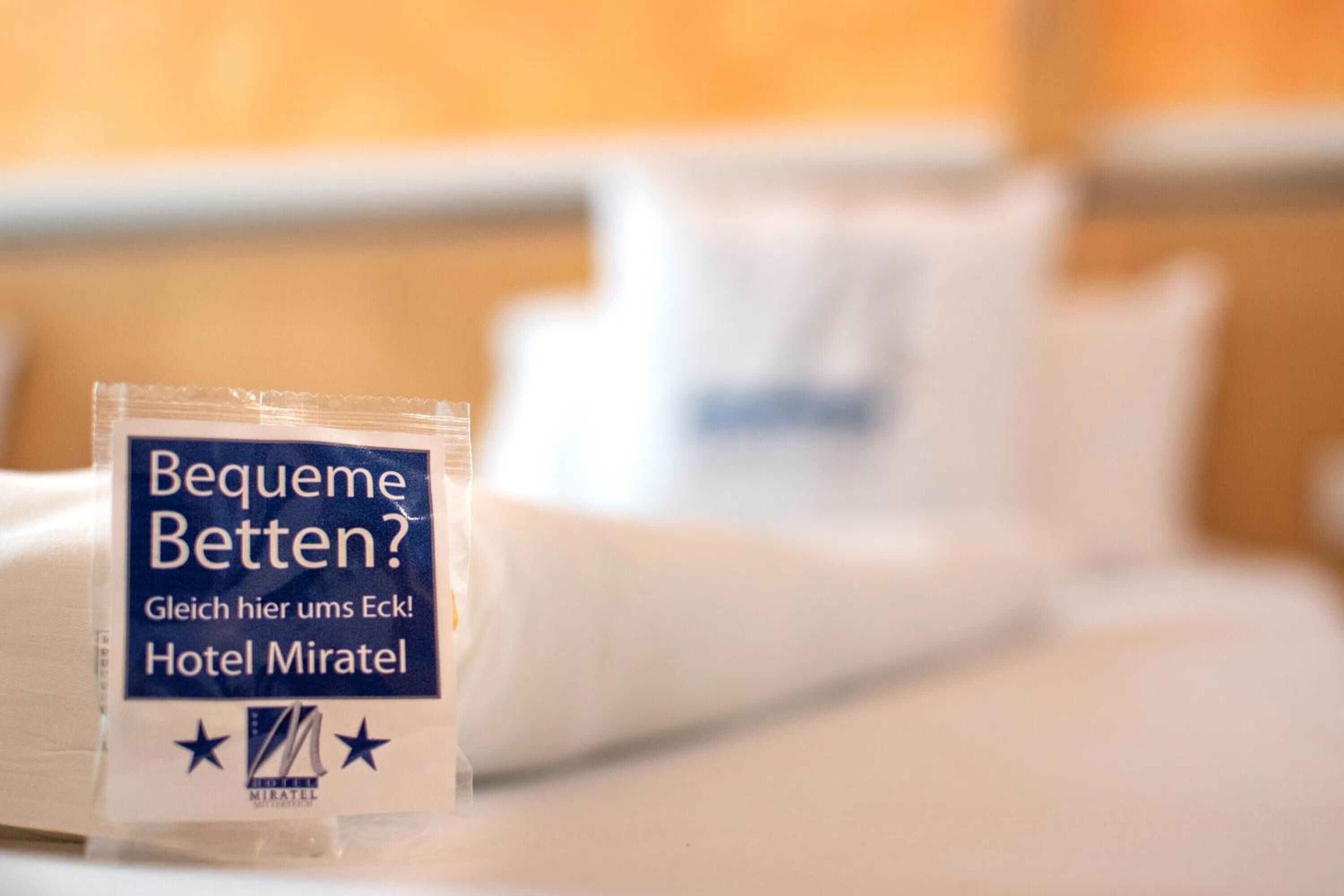 Un kit de artículos de aseo sobre una cama de hotel.