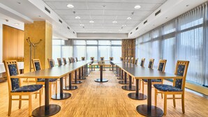 A conference room with a long table, chairs, and large windows.