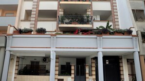 A multi-story residential building with balconies, a gated entrance, and a covered parking area. - MozÁrt B&B - Affittacamere (Andria)