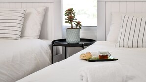 A hotel room with two beds, a small table with a tray of breakfast, a potted plant, and a window with a view. - Modern Gem with Stunning Balcony by Sea N Rent (Herzliya)