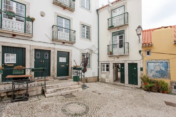 Stroll through charming streets lined with traditional European architecture, featuring cobblestone pavement, outdoor seating areas, and classic white facades.