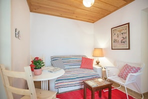 Relax in this inviting room with a comfortable bed, a reading nook, and a charming potted plant.
