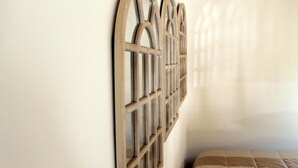 A room with a bed and a wall-mounted wooden decorative panel.