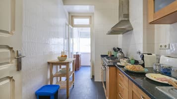 Enjoy cooking in this well-equipped kitchen with a stainless steel range hood, oven, and ample countertop space.
