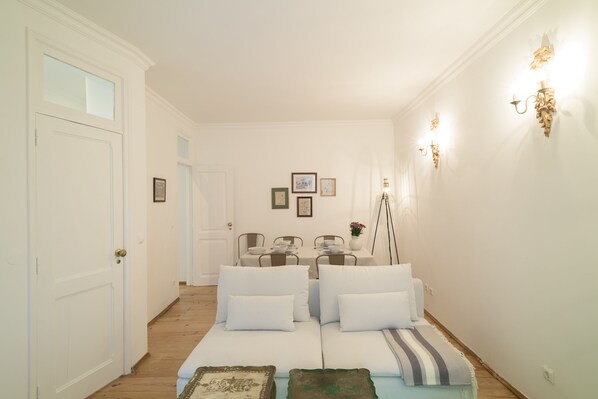 Relax in a stylish living area with a sofa, armchairs, and dining table, surrounded by framed artwork.