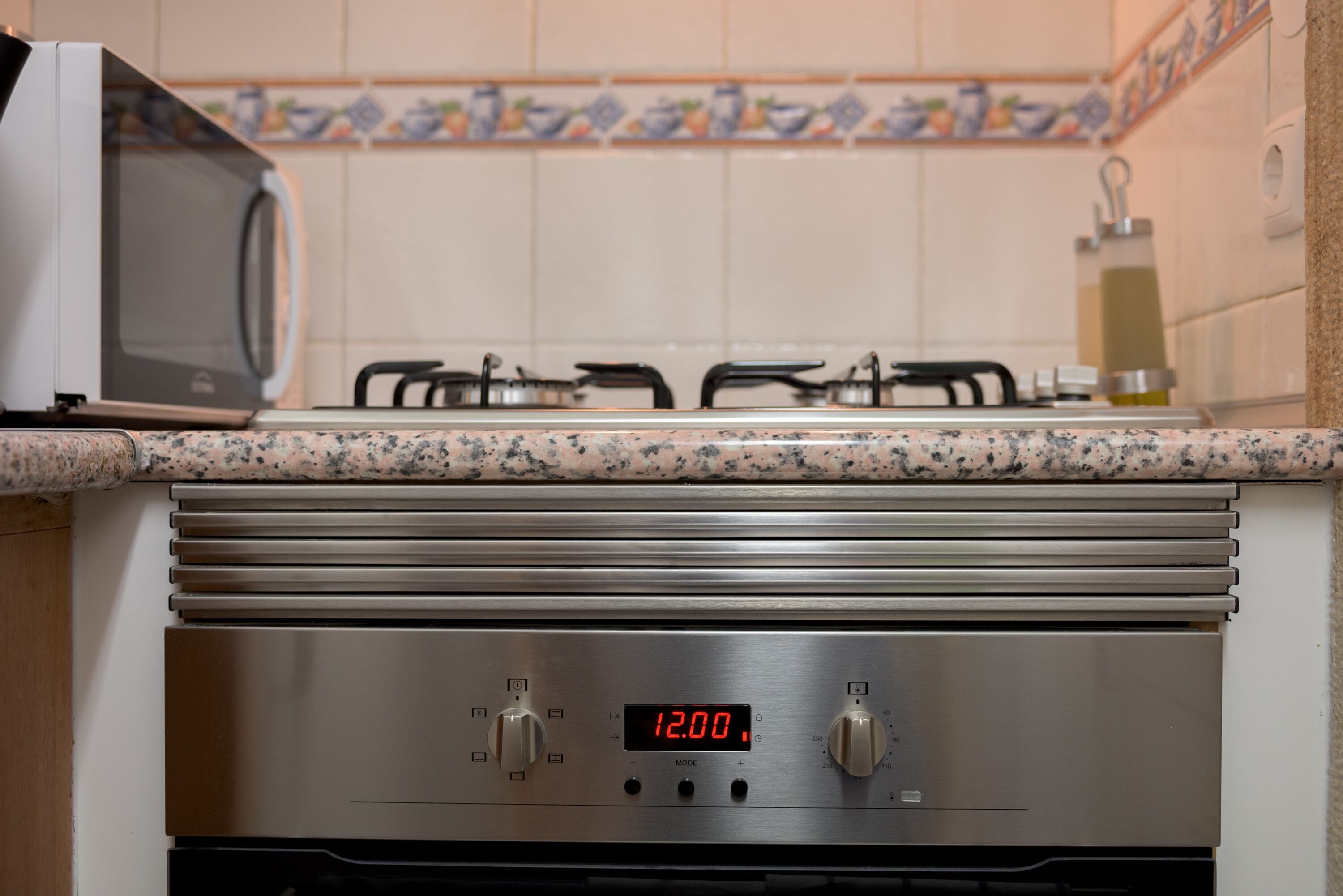 A kitchen with a microwave, gas stove, and stainless steel appliances.
