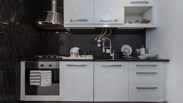 Enjoy cooking in this well-equipped kitchen with sleek cabinetry, an oven, and a coffee maker.