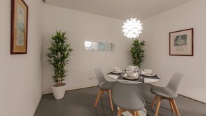 A modern dining area with a round table, grey chairs, and potted plants. - Renovated Apartment w/ Private Courtyard, By TimeCooler (Lisbon)
